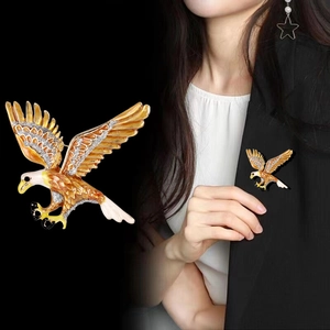 Golden eagle brooch with orange enamel and crystals on black blazer lapel