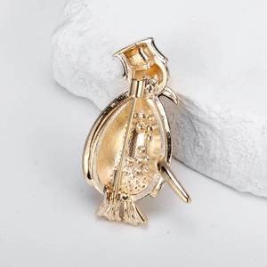 Back view of a cute golden penguin brooch pin with durable metal texture and secure clasp