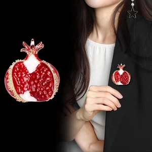 Elegant red enamel pomegranate brooch pin with gold plating shown on a black suit jacket