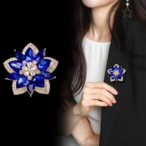 Blue crystal flower brooch with gold plating shown on model and in a close-up product shot