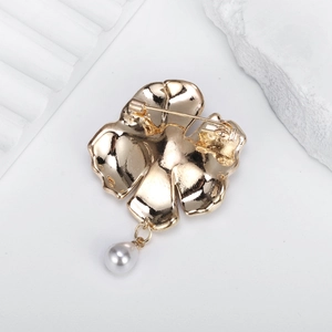 Broche fleur de camélia dorée avec pendentif en perle et vue arrière de l'épingle