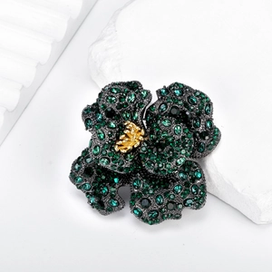 Vintage luxury rose brooch featuring deep green crystals and golden metal accents