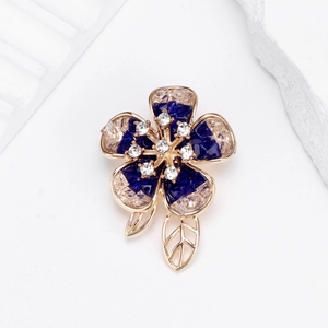 French camellia brooch with blue crystals and champagne stones in a gold floral design