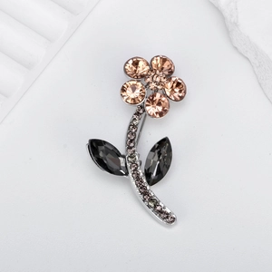 Elegant flower brooch with champagne rhinestones and grey crystals on a silver stem