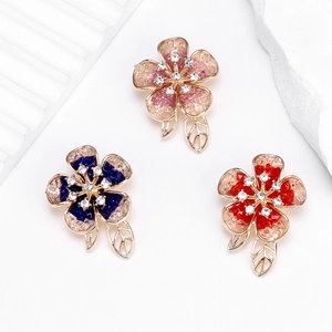 Elegant camellia flower brooches with crystals in pink, blue, and red floral designs