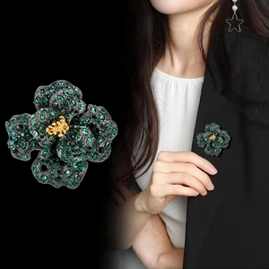 Vintage luxury peony brooch with green rhinestones and golden center on black blazer