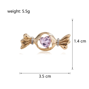 Broche bonbon dorée avec pierre en cœur rose et zircons sur fond blanc épuré