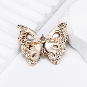 Vue arrière d'une luxueuse broche papillon en verre doré avec fermoir à épingle de sûreté