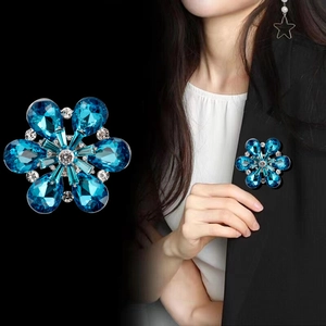 Broche fleur élégante avec cristaux bleus et zircon, vue en produit et sur un blazer