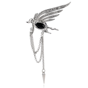 Detailed close-up of silver phoenix brooch with rhinestones, black gem, and long chain tassels