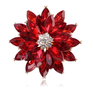 Detailed view of layered red crystal flower brooch with rhinestone core in gold setting