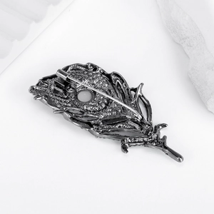 Exquisite peacock feather brooch with leaf shape and gunmetal finish on a white background