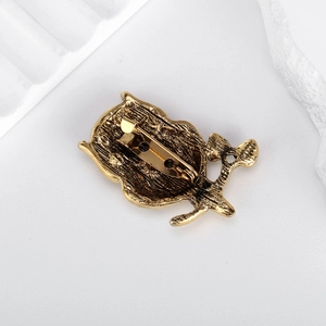 Vintage gold owl brooch back view showing secure safety pin and textured alloy finish