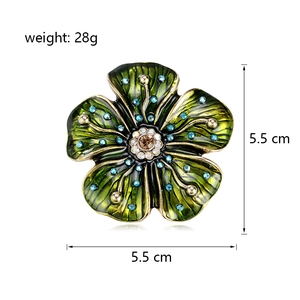 Broche fleur vintage en émail vert avec cristaux bleus et cristal central marron