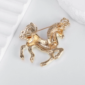 Back view of golden horse brooch featuring pin closure and textured metal surface