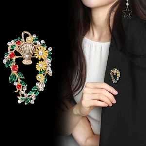 Eleganter Blumenkorb-Anstecker mit Gänseblümchen und roten Beeren auf schwarzem Anzug