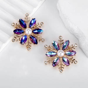 Broche flocon de neige avec cristaux bleus et perle sur une base dorée chic