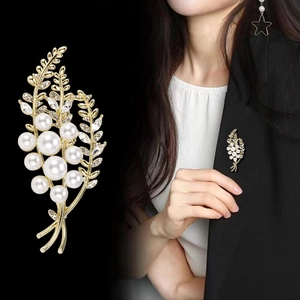 Broche élégante en perles de blé pour femme sur blazer noir et vue rapprochée