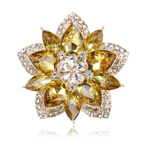 Detail of amber crystal flower brooch with layered petals and gold-plated finish