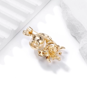 Broche chouette créative avec perle blanche sur métal doré et détail de l'épingle