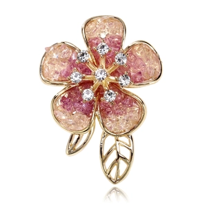 Detailed close-up of crystal flower brooch with pink gradient petals and rhinestone center