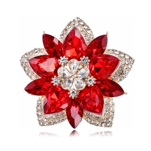 Close-up of red crystal flower brooch with gold plating and sparkling gemstones