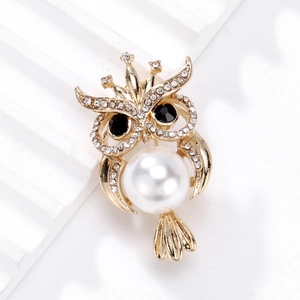 Broche hibou dorée élégante avec perle blanche et couronne de strass sur pierre