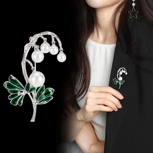 Elegante Maiglöckchen-Brosche mit Perlen und grünem Emaille auf schwarzem Blazer
