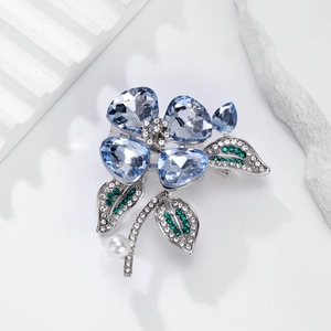 Elegant crystal flower brooch with light blue petals and white pearl on white stone base