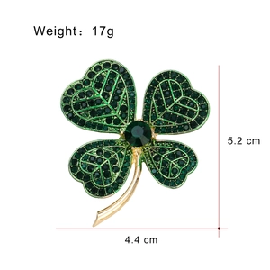 Elegante gouden klavertje vier broche met groene strass steentjes en een edelsteen