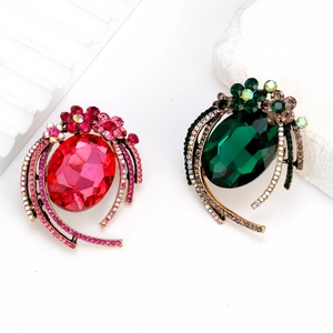 Detailed macro view of vintage alloy brooches with large oval glass gems and floral accents