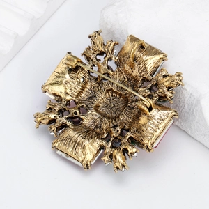 Broche vintage en alliage doré avec pierres en verre coloré vue de l'arrière ornementé