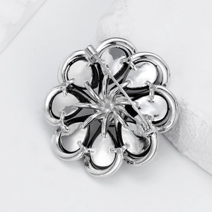 Floral alloy brooch with silver finish and safety pin back on white mineral stone