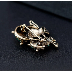 Retro bronze owl brooch back view showing secure safety pin clasp on black leather