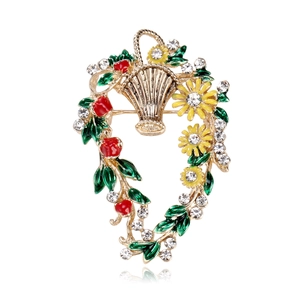 Detail einer Blumenkorb-Brosche mit buntem Emaille-Dekor und funkelnden Kristall-Akzenten