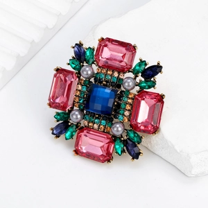 Broche vintage en alliage avec gemme bleue et strass roses sur support en pierre blanche
