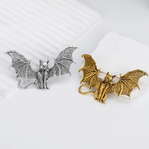 Vintage winged cat brooch in antique gold and silver with a gothic bat wing design