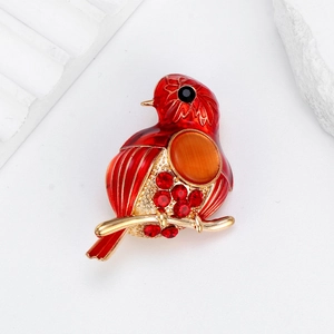 Broche oiseau chic en émail rouge avec strass et pierre œil de chat sur branche dorée
