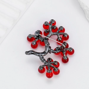 Detailed back view of berry branch brooch with red beads and secure metal pin clasp