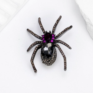 Spider brooch with black gemstone and champagne crystal accents on white stone