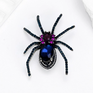 Spider brooch with silver base and large oval dark blue gemstone body in high detail
