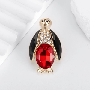 Chic penguin brooch with red crystal, black enamel wings, and sparkling zircons