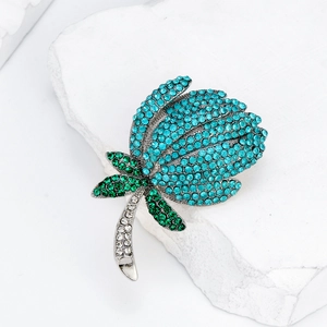 Broche tulipe élégante avec strass bleus et verts sur un support en pierre blanche