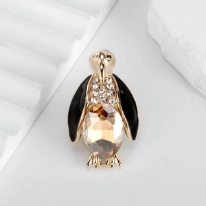 Golden penguin brooch with black enamel, white zircons and champagne gemstone