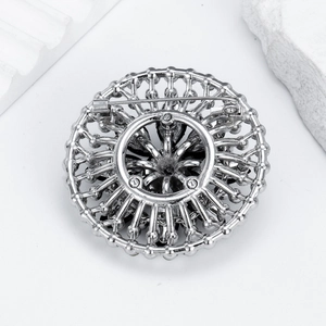 Elegant silver hollow brooch with a radial grid structure and secure pin on the back