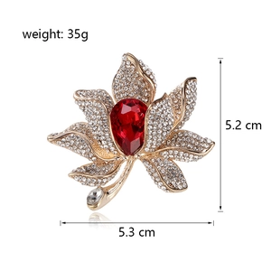 Golden maple leaf brooch with sparkling crystals and red pear-shaped gemstone centerpiece