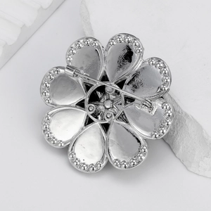 Silver flower brooch with petal design and secure pin closure shown from the back view