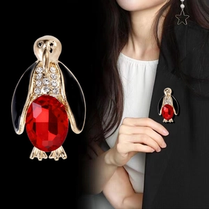 Cute penguin brooch featuring large red gemstone and sparkling rhinestones on golden base