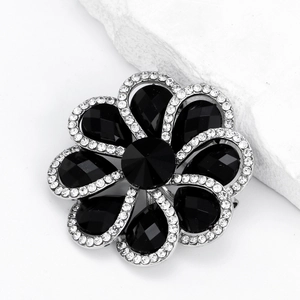 Elegant flower brooch with black crystal petals and white rhinestone trim on silver base