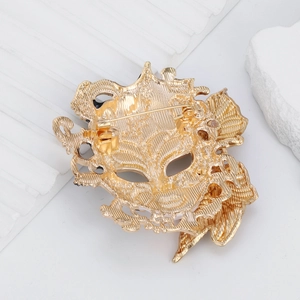 Golden mask brooch with vintage relief and safe pin clasp shown from the back